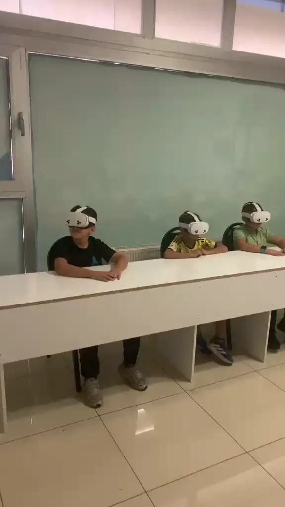 VR Meta Quest sınıfımızda başlıklarını takmış, sanal gerçeklik dersini izleyen üç öğrenci
